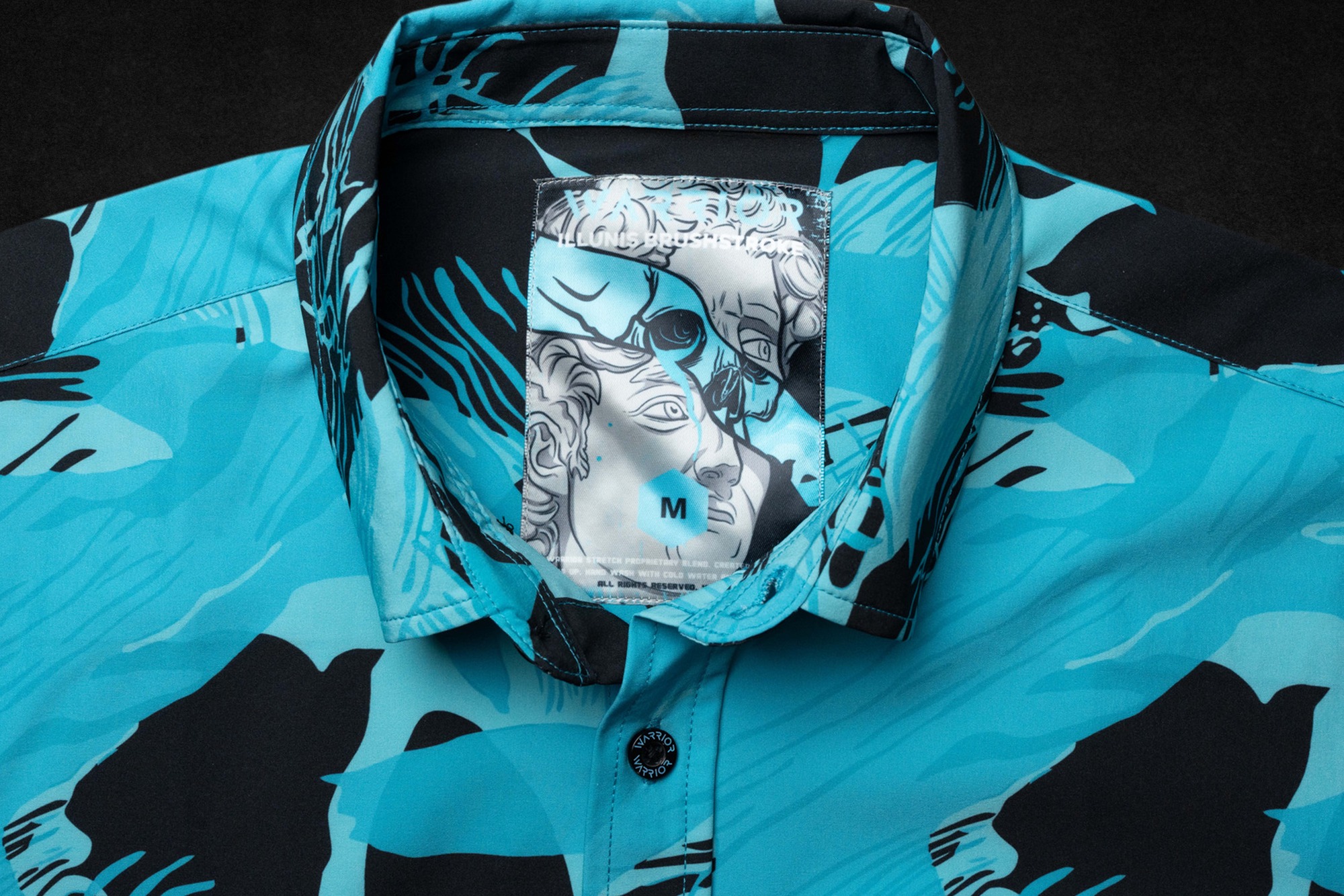 Illunis Brushstroke tag sewn into a teal garment collar